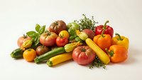 Fresh organic vegetables and herbs arranged on white background including tomatoes, peppers, zucchini, basil and thyme for healthy cooking and nutrition.