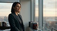 Woman in business attire standing by office window overlooking cityscape, professional corporate environment, suitable for business, leadership, and corporate themes.