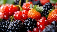 Fresh mixed berries collection with strawberries, blackberries and red currants showcasing vibrant colors and natural textures for healthy eating concepts.