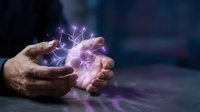 Male hands cupping glowing purple lightning energy with electric sparks and magical light effects against dark background for fantasy concepts.