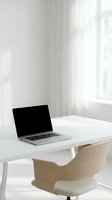 Modern minimalist home office workspace with open laptop on white desk and wooden chair by bright window for remote work and productivity.