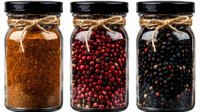 Glass jars filled with aromatic spices and peppercorns - ground cinnamon powder, pink peppercorns, and black peppercorns decorated with rustic twine bows on black lids.