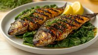 Grilled whole fish with charred skin served on bed of fresh greens, garnished with rosemary and lemon wedges for Mediterranean-inspired seafood dish.