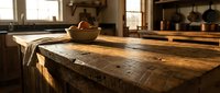 Rustic wooden kitchen island with weathered planks and ceramic bowl in warm sunlit farmhouse interior with vintage cookware and natural lighting.