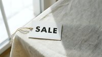 Sale tag on linen fabric near window, retail discount concept for shopping, fashion, and seasonal promotion campaigns.