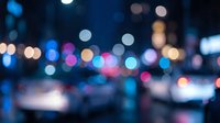 Abstract blurred city lights at night with colorful bokeh effect creating dreamy urban atmosphere for backgrounds and design projects.
