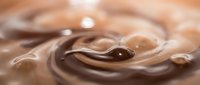 Smooth chocolate swirl with glossy liquid texture and droplets, suitable for food, beverage, and confectionery design projects.