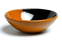 Modern ceramic bowl in orange and black color scheme with minimalist two-tone design on white background, isolated for commercial and decorative use.