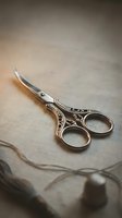 Ornate silver embroidery scissors with decorative handles resting on neutral fabric with thread and thimble, suitable for sewing, crafting, and needlework projects.