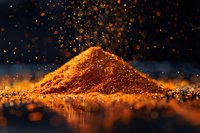 Glowing heap of orange spice powder with floating particles against dark background, dramatic lighting creates magical atmosphere for culinary and food photography.