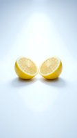 Fresh lemon halves cut in half showing juicy pulp and seeds on clean white background for healthy cooking and citrus fruit concepts.