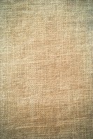 Natural beige burlap fabric texture with woven pattern and vignette edges creates rustic background for eco-friendly design projects and vintage style layouts.