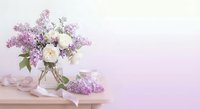 Purple lilac flowers and white roses bouquet in glass vase on wooden table with pink ribbon against soft pink background for spring decor and celebrations.