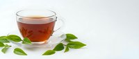 Fresh herbal tea in transparent glass cup with green leaves on white background. Natural wellness drink for relaxation and healthy lifestyle.