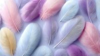 Soft pastel feathers in pink, purple and blue tones scattered on light background for delicate design projects and feminine decorative elements.