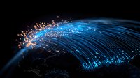 Glowing fiber optic network lines connecting across North America shown on dark background with light trails representing digital data flow and connectivity.