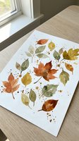 Watercolor autumn leaves painting on paper with orange, yellow and green foliage scattered with paint splatters for seasonal art projects and home decor.