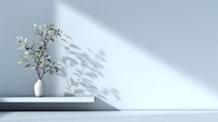 Minimalist white vase with olive branch on floating shelf casting delicate shadow on light wall, creating serene contemporary home decor atmosphere.