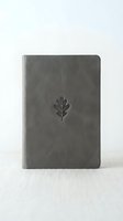 Gray leather journal with embossed oak leaf on cover, standing upright on light textured surface, minimalist style for stationery and lifestyle content.