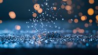 Water drops splashing on blue reflective surface with orange bokeh lights in background creating magical atmospheric effect. Macro photography with selective focus.