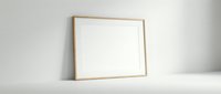 Empty wooden frame mockup on white surface against neutral wall for artwork display and interior design projects.