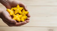Yellow star shapes held in open hands against wooden background, symbolizing success, achievement, and customer satisfaction for business and service concepts.