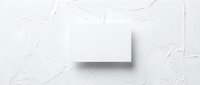 Blank white business card mockup on textured white surface for branding and corporate identity design projects.
