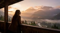 Woman with long dark hair gazing at misty mountain valley at sunrise from wooden cabin balcony, surrounded by evergreen forest and golden clouds.