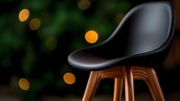 Modern black leather chair with wooden legs against dark green background with golden bokeh lights creating luxurious atmosphere for interior design.