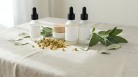 Natural skincare products with dropper bottles and herbal ingredients on linen fabric. Organic cosmetics setup for beauty and wellness routines.