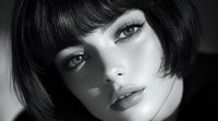 Close up portrait of young Caucasian woman with short dark bob hairstyle, dramatic makeup and expressive eyes in black and white artistic photography style.