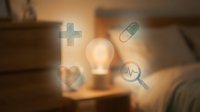 Healthcare innovation and medical research concept with glowing lightbulb surrounded by floating health icons including plus sign, pill, heartbeat and magnifying glass on blurred office background.
