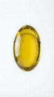 Golden yellow vitamin E capsule isolated on white background for health and wellness supplement design applications.