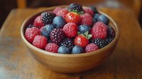 Fresh mixed berries in wooden bowl on rustic table featuring raspberries blueberries blackberries for healthy eating organic food photography.