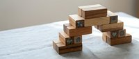 Wooden building blocks with checkmark symbols stacked in balanced tower formations on marble surface for educational play and development activities.