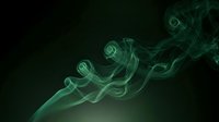 Green smoke swirling in elegant curls against a dark background, creating a mystical and atmospheric effect for creative design projects.