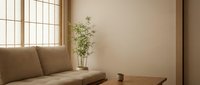 Minimalist living room with beige sofa, wooden table, potted plant, and natural light from window. Suitable for interior design, home decor, and lifestyle content.