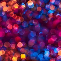 Vibrant bokeh lights create magical atmosphere with red, blue and orange glowing circles on dark background, defocused abstract pattern for festive designs.