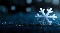 Delicate snowflake crystal on dark glittering surface with bokeh lights in background creates magical winter atmosphere for seasonal designs and holiday cards.