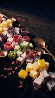 Colorful Turkish delight cubes with powdered sugar on dark surface with golden spoons and rose petals for gourmet dessert and confectionery concepts.
