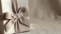 Elegant gift box wrapped in neutral linen fabric with a luxurious velvet bow, perfect for holiday, wedding, or premium brand packaging concepts.