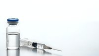 Medical vial with clear liquid and syringe on white background for healthcare, vaccination, pharmaceutical research and treatment concepts.