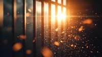 Dramatic sunlight streaming through window blinds creating atmospheric dust particles and golden bokeh effect in dark room. Perfect for mood designs.
