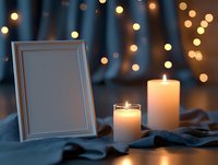 Empty white photo frame with glowing candles on blue fabric against blurred bokeh lights background, creating romantic atmosphere for special occasions.