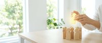 Businessperson placing wooden blocks in ascending order on white table near bright window, symbolizing growth, progress, and business development strategy.