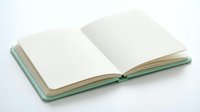 Open blank notebook with empty white pages and green cover on white background for writing, journaling, and creative projects.