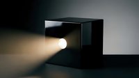Vintage film projector with glowing lens emitting warm light beam in dark studio setting, suitable for cinema, media, entertainment, and technology concepts.