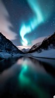 Vibrant aurora borealis dancing over frozen mountain valley with starry night sky and calm water reflection below.