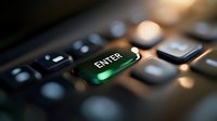 Illuminated green enter key on black computer keyboard with dramatic lighting and shallow depth of field, highlighting technology interface.
