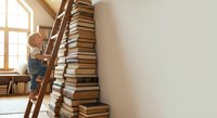 Young child climbing wooden ladder next to towering stack of books in bright room with natural light for educational and learning concepts.